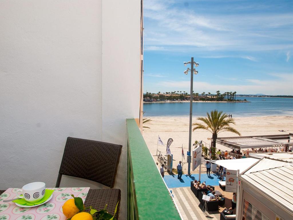 Apartment Xara Torres, at the Beach of Alcudia في بورت ذالكوذيا: شرفة مع طاولة وإطلالة على الشاطئ