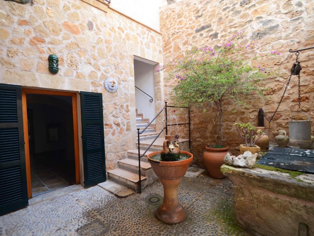 アルクーディアにあるHouse Sant Jaumeの植物の中庭のある石造りの建物の入り口