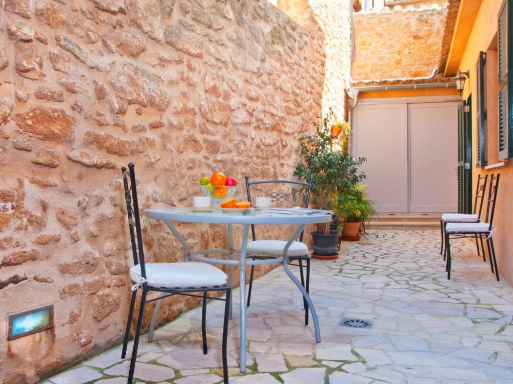 Un patio con una mesa y sillas en un muro de piedra. en House Ca Na Polida, en Alcudia