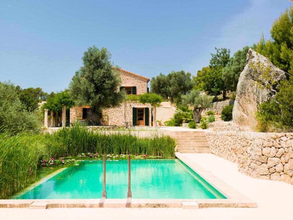 a villa with a swimming pool in front of a house at Villa Finca Garrafa para 6 con piscina en Port d'Andratx in Andratx