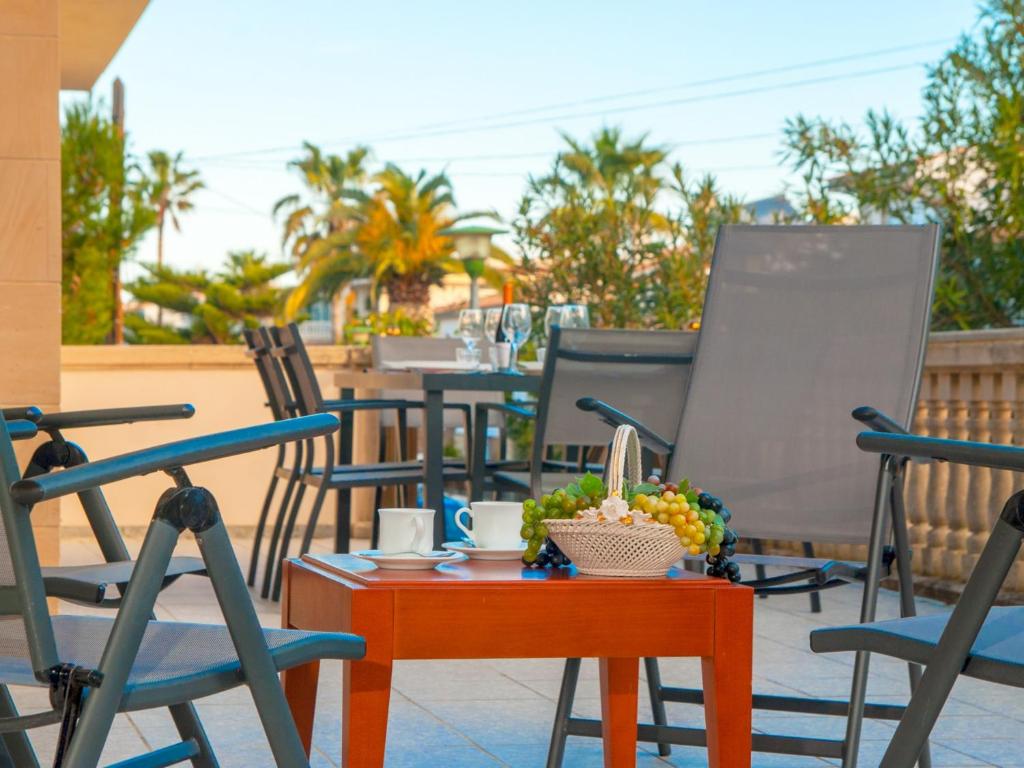 een groep stoelen en een tafel met een fruitschaal bij Villa Can Canta Natura Park House at Platja de Muro Beach in Playa de Muro