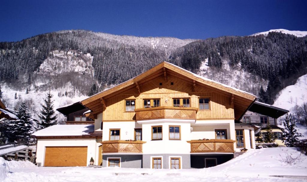 ein Haus im Schnee vor einem Berg in der Unterkunft Haus Dekorso in Dorfgastein