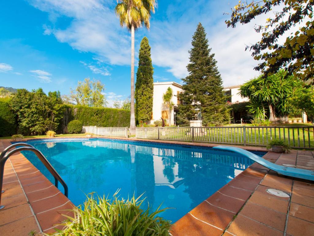 a swimming pool with a fence and trees at Villa Tramontana de Lloseta, piscina y vista montaña in Lloseta