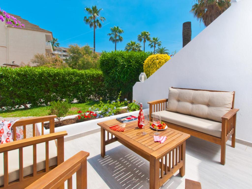 a patio with two benches and a table and a couch at Apartment Mar del Plata in Alcudia beach in Alcudia