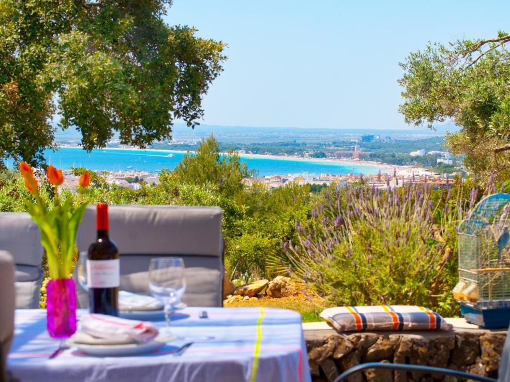 una mesa con una botella de vino y vistas al océano en Villa Sa Rota, con piscina y vista mar, en Alcudia
