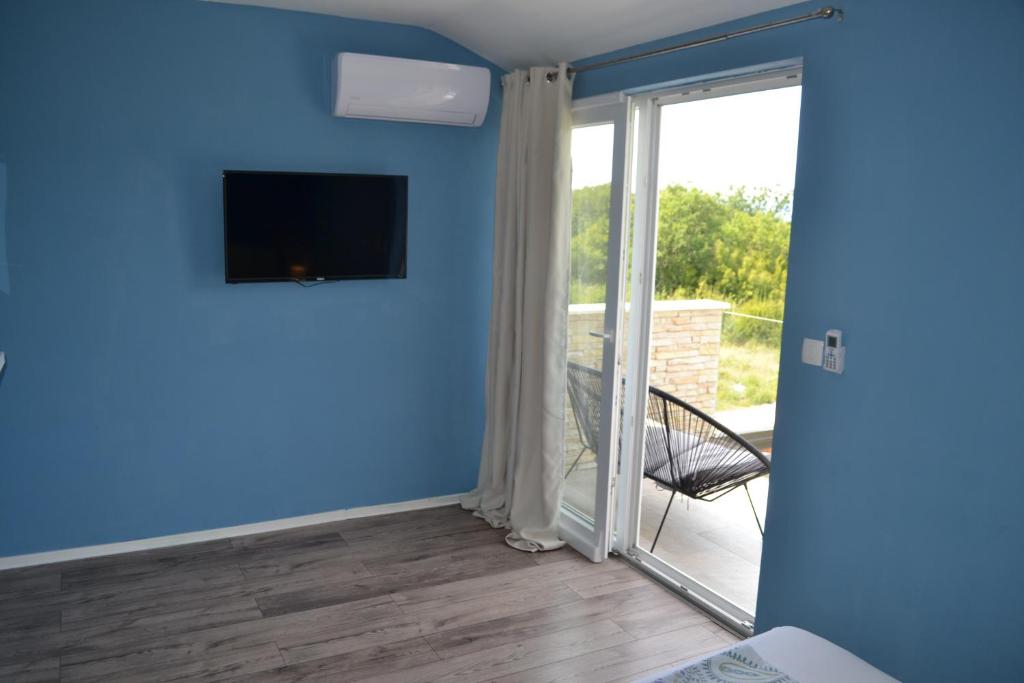 Pokój z przesuwnymi szklanymi drzwiami prowadzącymi na balkon. w obiekcie APARTMENT GLORIA Blue 1 w mieście Malinska