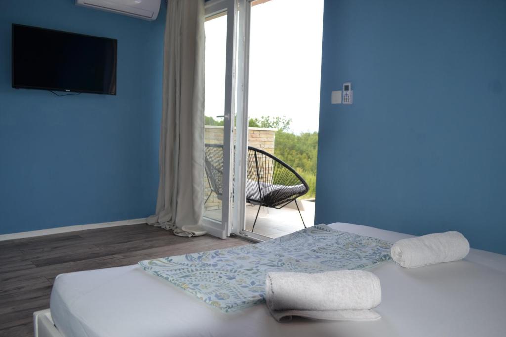 niebieski pokój z 2 łóżkami i przesuwnymi szklanymi drzwiami w obiekcie APARTMENT GLORIA Blue 1 w mieście Malinska