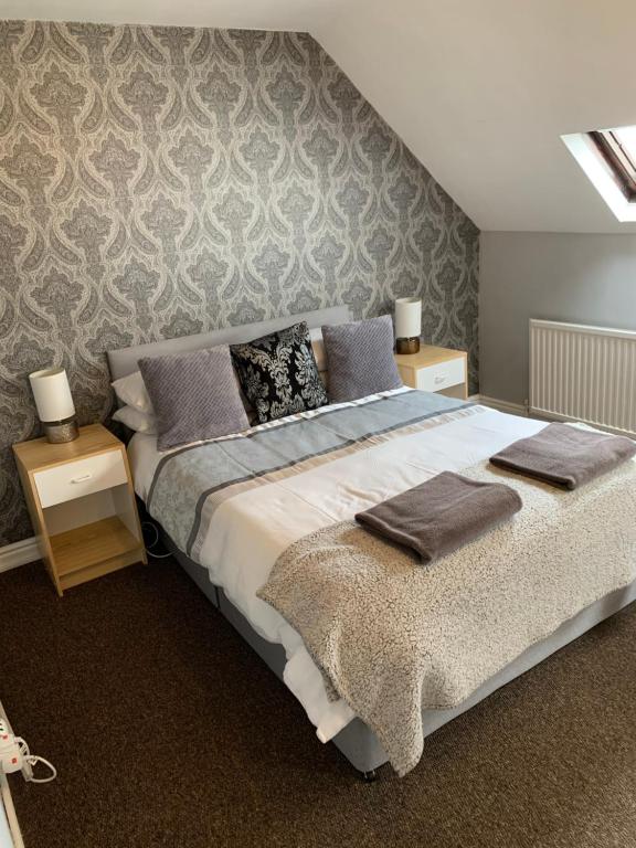 1 dormitorio con 1 cama grande y 2 mesitas de noche en Gillygate Holiday Apartment, en York