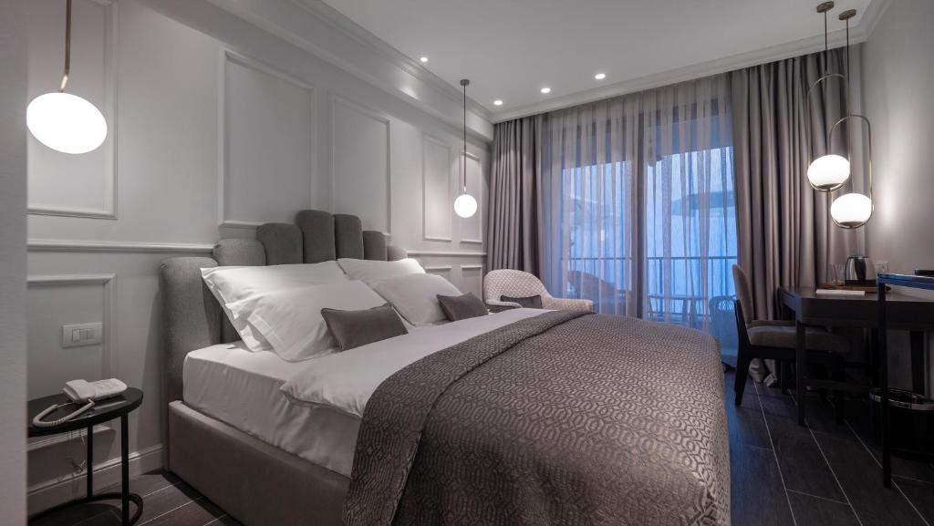 a bedroom with a large bed and a desk and a desk at Vivid Blue Serenity Resort in Sveti Stefan