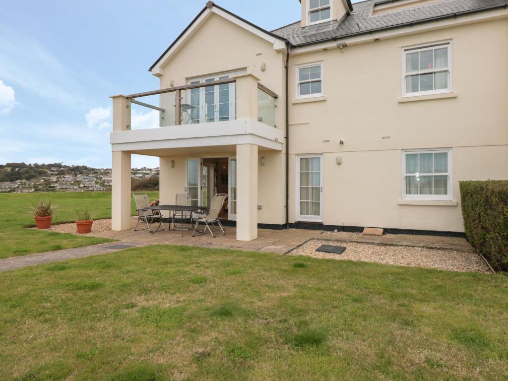 a house with a patio with a table and chairs at 4 Thurlestone Beach House in Kingsbridge