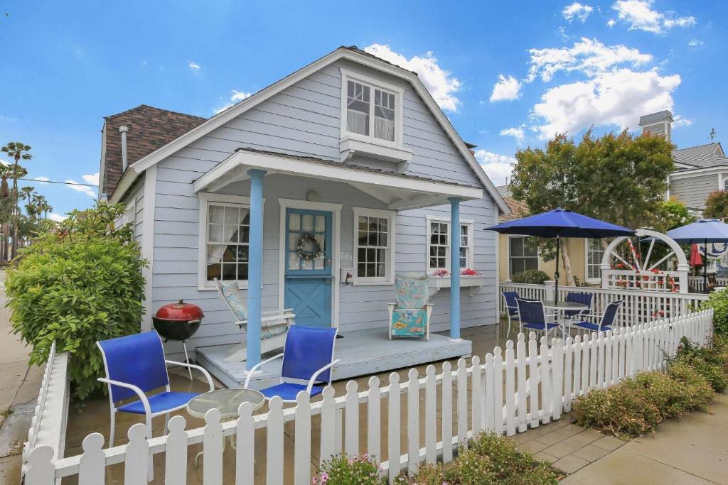 a tiny house with blue chairs and a fence at 201 Amethyst Avenue in Newport Beach