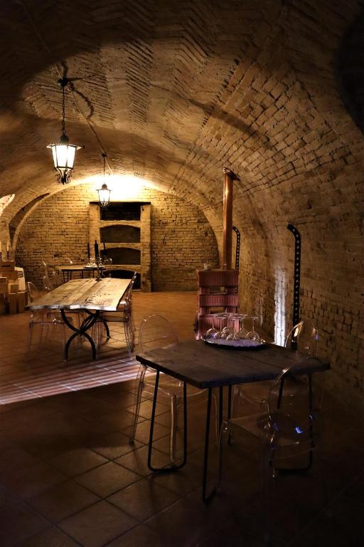 CalossoTenuta Le More的砖砌建筑中带两张桌子的房间