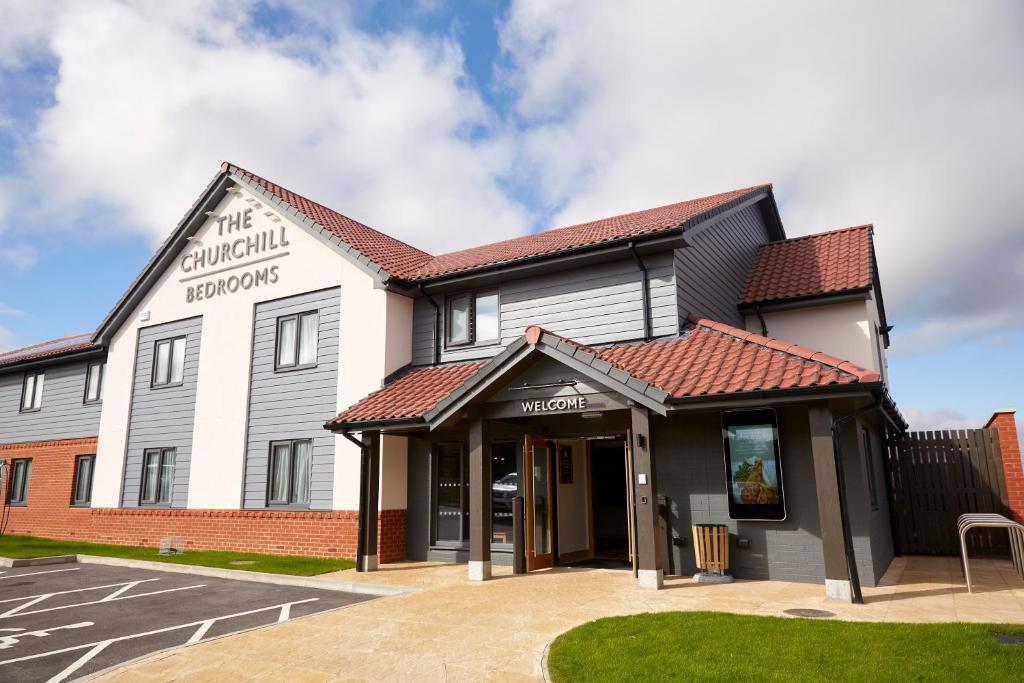 a large white building with a red roof at The Churchill By Greene King Inns in Royal Wootton Bassett