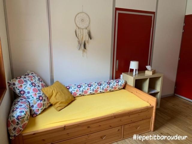 a room with a bed and a couch with pillows at Backpacker Le Petit Baroudeur in Champéry