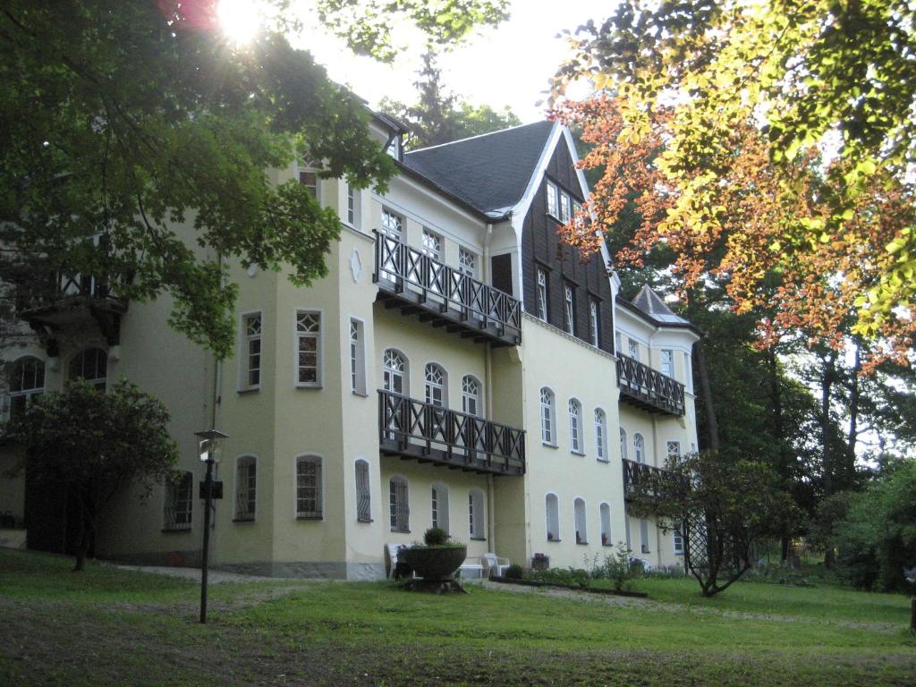 un gran edificio blanco con balcones. en Villa Wilisch en Amtsberg