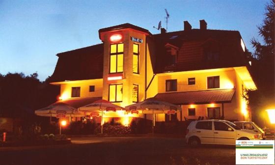 a building with a car parked in front of it at Hotel Twardowski in Głogoczów