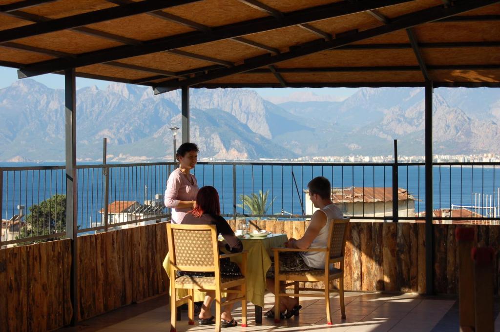 安塔利亞的住宿－二十酒店，一群人坐在阳台上的桌子旁