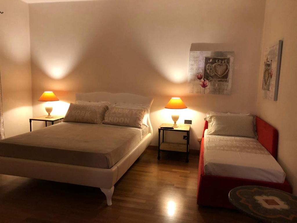 2 lits dans une chambre avec 2 lampes sur des tables dans l'établissement Lanna b&b, à Novoli