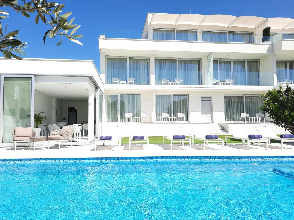 a building with a swimming pool in front of a building at B&B Demar Residence & Dependance in Zadar