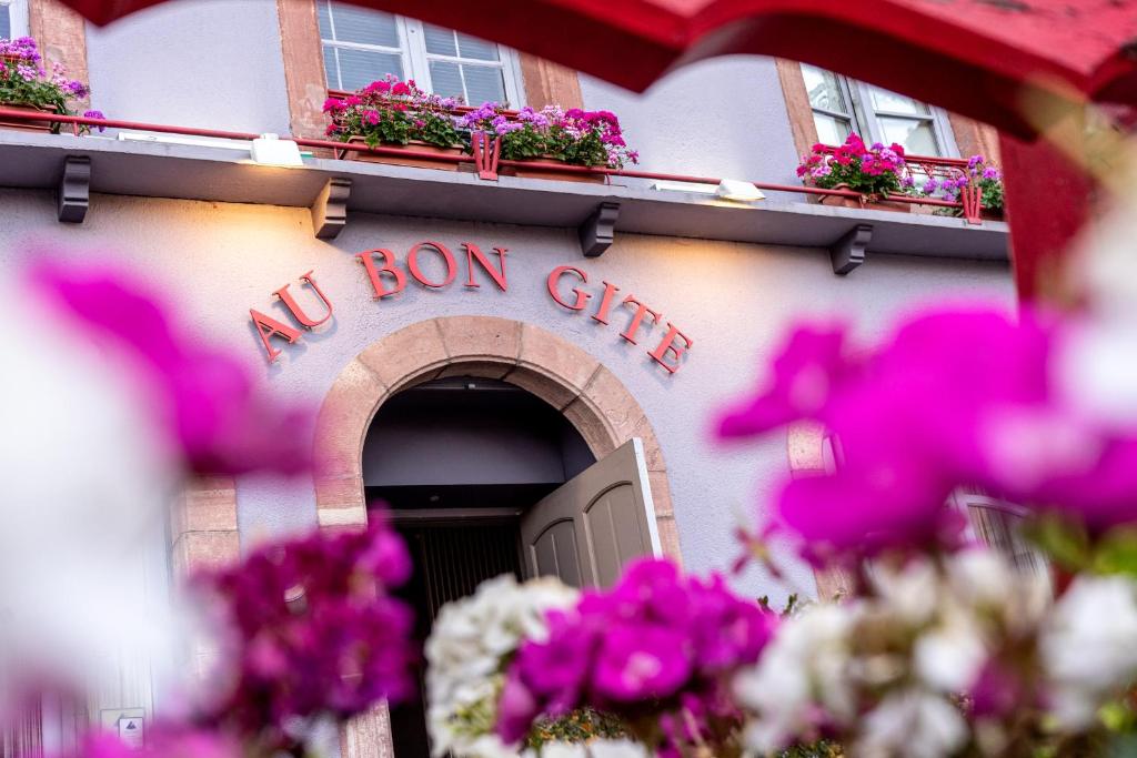 ein Gebäude mit einer Tür ohne Bogenschild und Blumen in der Unterkunft Au Bon Gîte in Senones