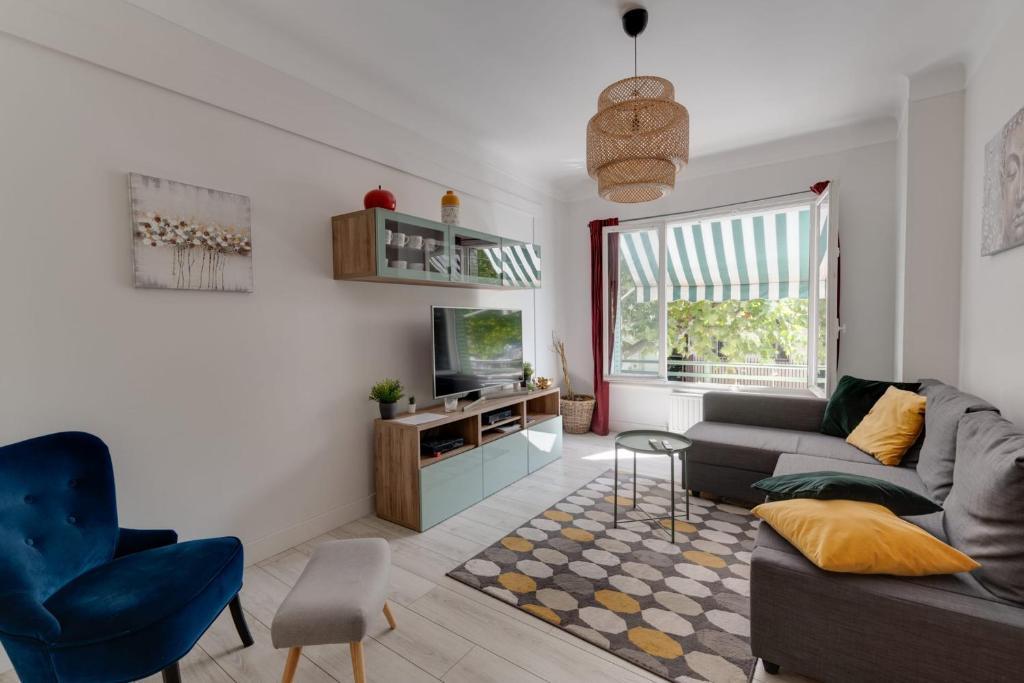 een woonkamer met een bank en een tv bij Le Baulier - 2 bedrooms apartment in Annecy