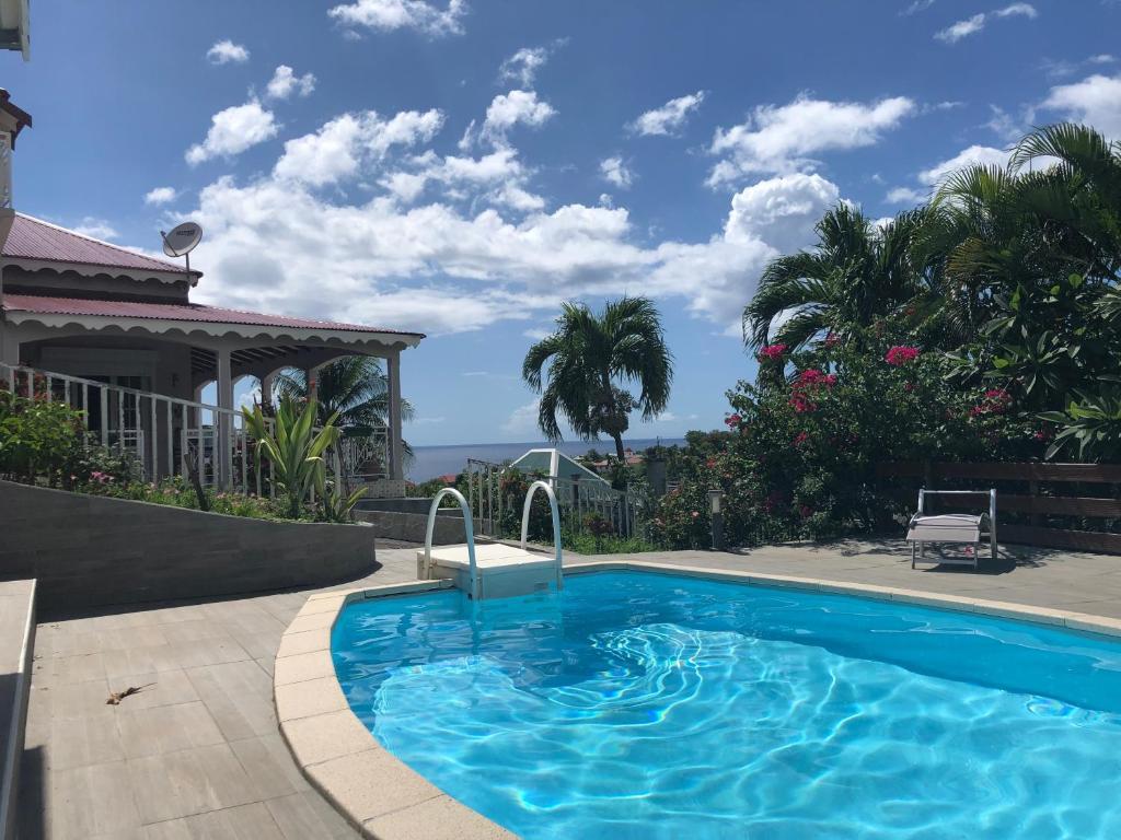 a swimming pool in front of a house at Mawima in Vieux-Habitants