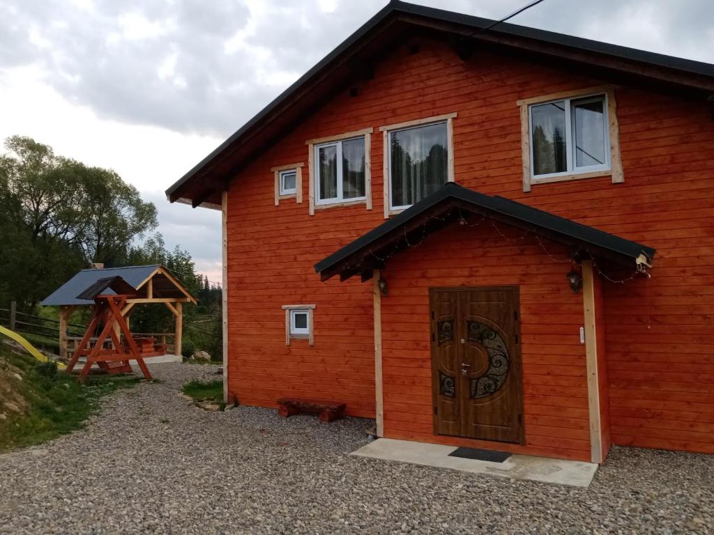 ein Blockhaus mit einer Tür und einem Pavillon in der Unterkunft Шпінь 2 in Worochta