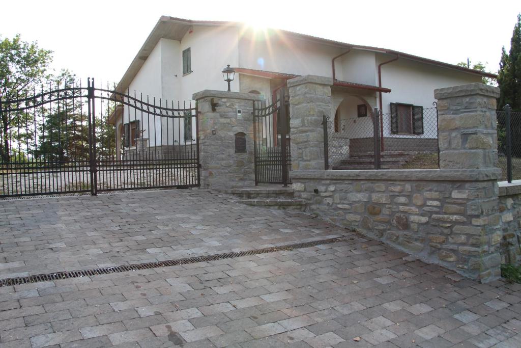 a house with a fence and a brick driveway at Villa Raggio della Valle in Bagno di Romagna