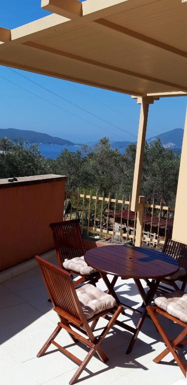 a table and two chairs on a patio with an umbrella at Apartments Danilo Kažanegra in Sveti Stefan