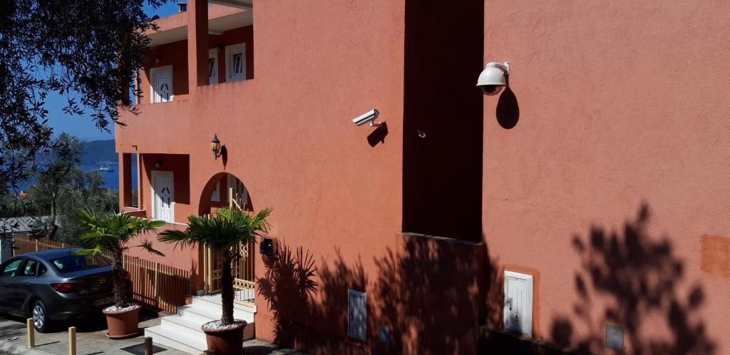 a red building with a car parked in front of it at Apartments Danilo Kažanegra in Sveti Stefan