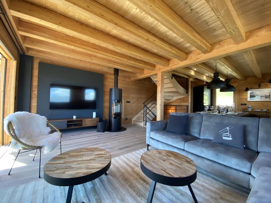 a living room with a couch and two tables at LAKE LOUISE Chalet mitoyen proche pistes avec vue panoramique in La Toussuire