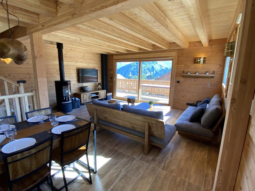 a living room with a couch and a table at WHYMPER Chalet mitoyen proche pistes avec vue panoramique in La Toussuire
