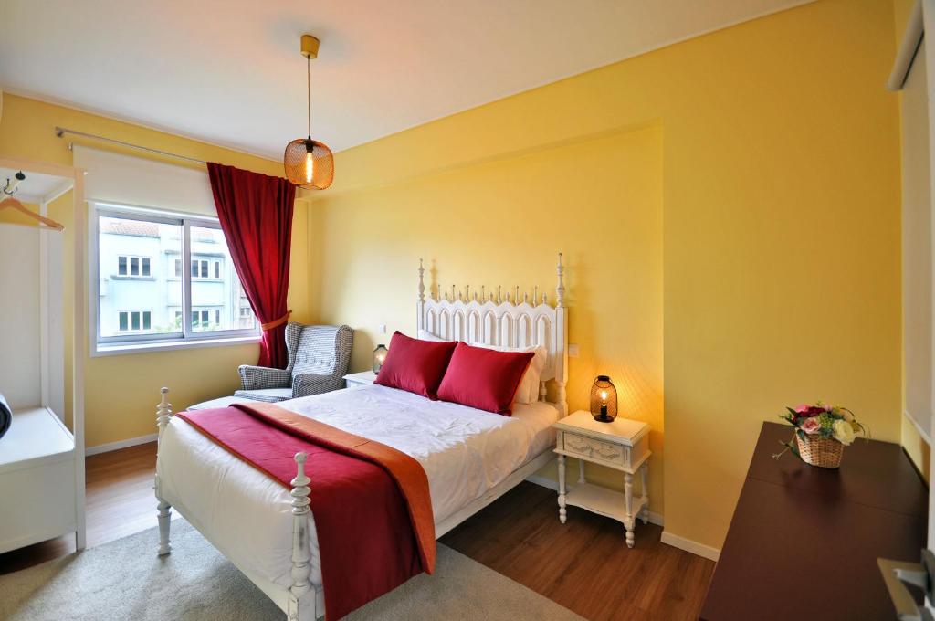 a bedroom with a bed with red pillows and a window at RH Charming Apartment Liberdade I in Braga