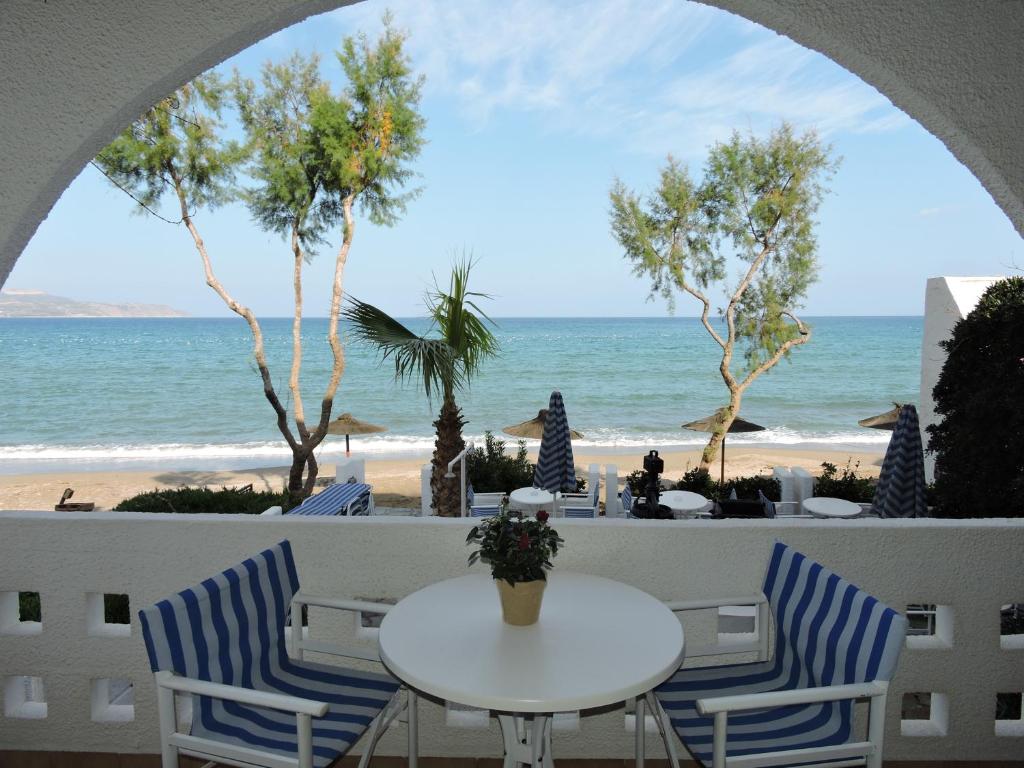 a table and chairs with a view of the beach at Thamirakis Studios in Kalyves