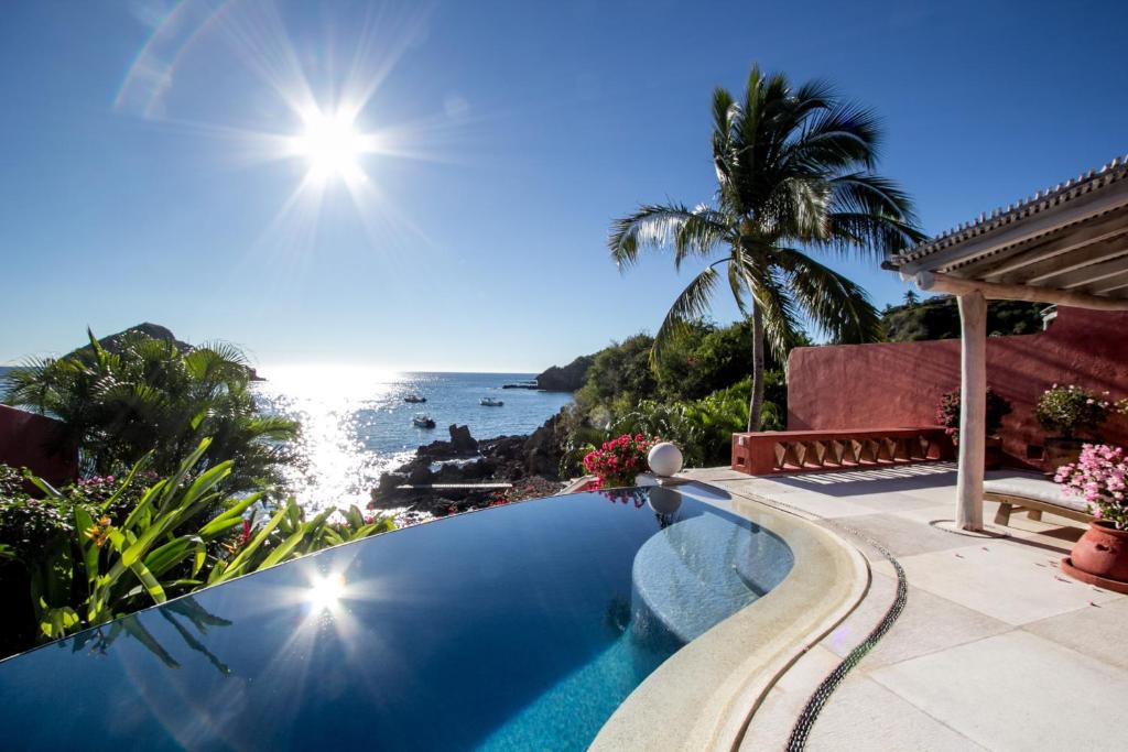 a swimming pool with a view of the ocean at Casa Azul & Casa Carioca in Careyes in Careyes