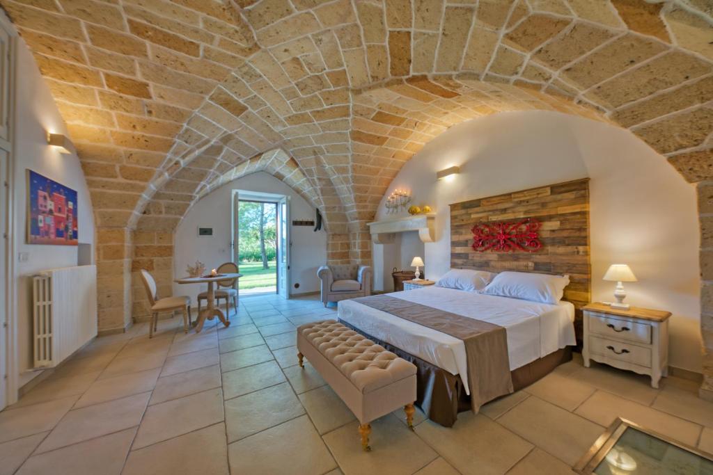 1 dormitorio grande con 1 cama grande y pared de piedra en b&b Casale Vecchio Lecce, en Arnesano