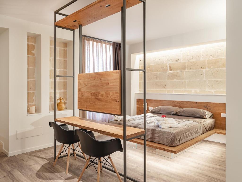 Schlafzimmer mit einem Bett, einem Schreibtisch und Stühlen in der Unterkunft Casenelcuore - Holiday Rooms in Matera