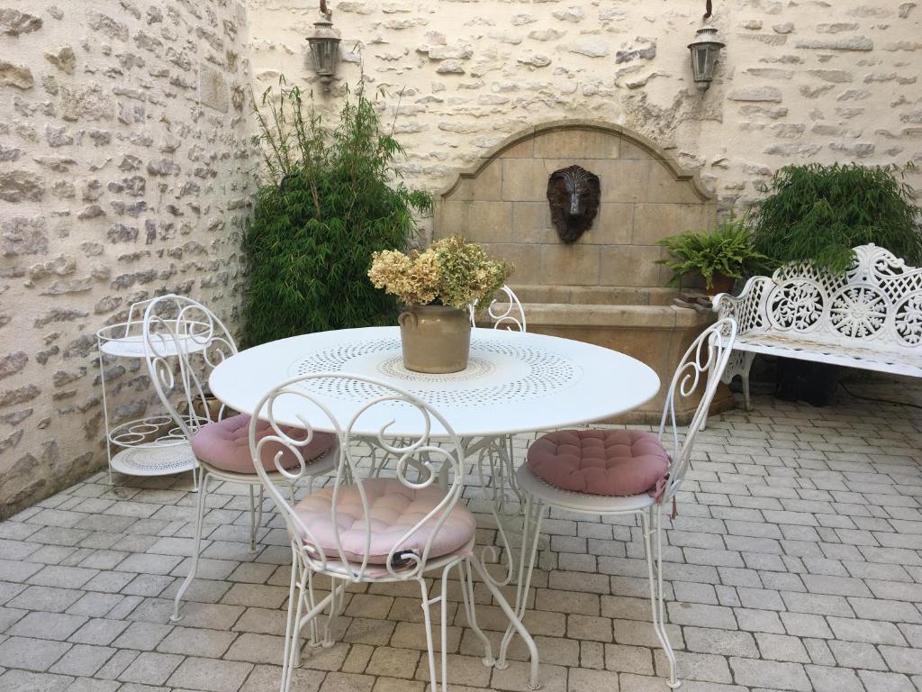 einen weißen Tisch und Stühle auf einer Terrasse in der Unterkunft Maison Galimard in Flavigny-sur-Ozerain