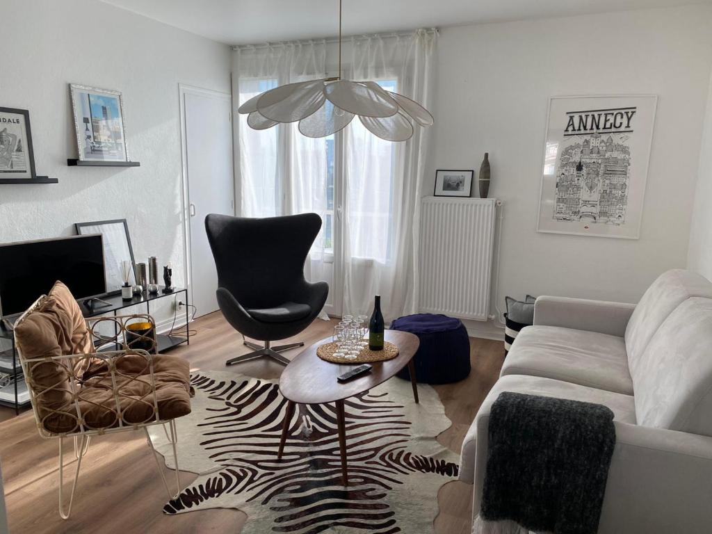 un soggiorno con un divano, un tavolo e delle sedie di Appartement à 300 m du lac et des commerces ad Annecy