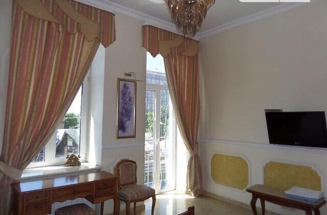 uma sala de estar com uma mesa e uma grande janela em Beautiful apartment in the center of Vinnytsia em Vinnytsya