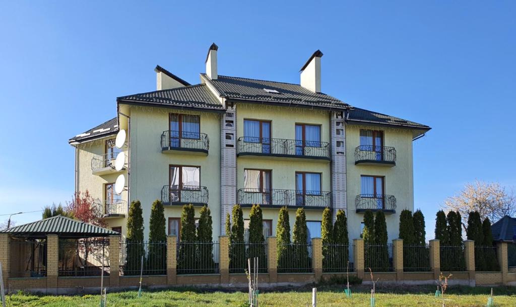 uma casa grande com uma cerca em frente em Hermes Resort Hotel Rest and Treatment em Truskavets