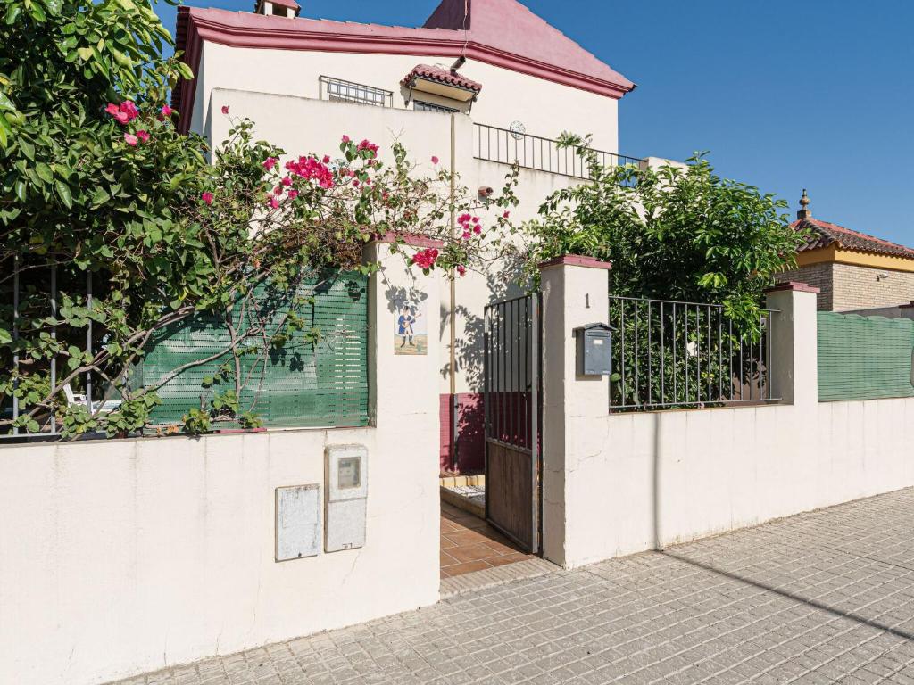 a white house with a gate and a fence at Belvilla by OYO Casa de Rudi in Seville