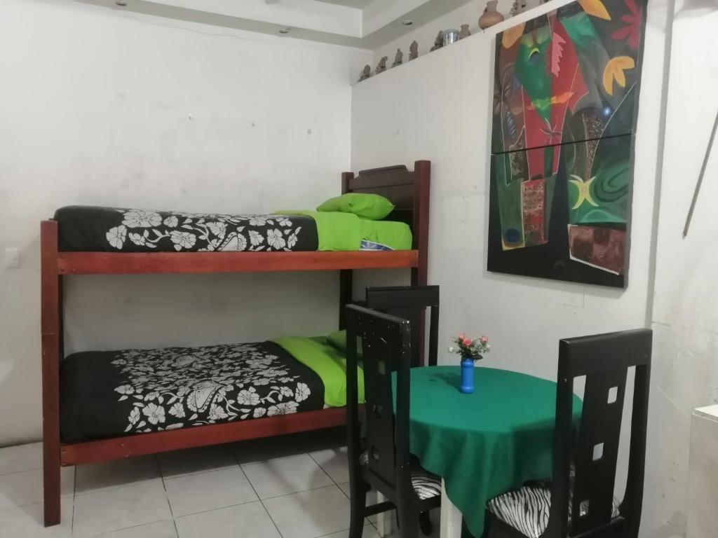 Cette chambre comprend 2 lits superposés et une table. dans l'établissement Escocie - Quito, à Quito