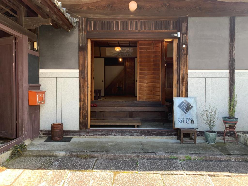 a entrance to a building with a bench in front of it at Guesthouse SHIGI in Nakatsugawa