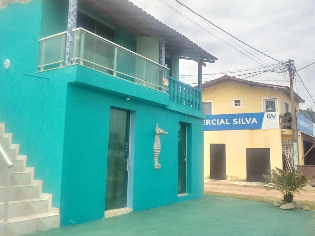 a blue building with a balcony on top of it at Apartamentos no Farol Velho in Salinópolis