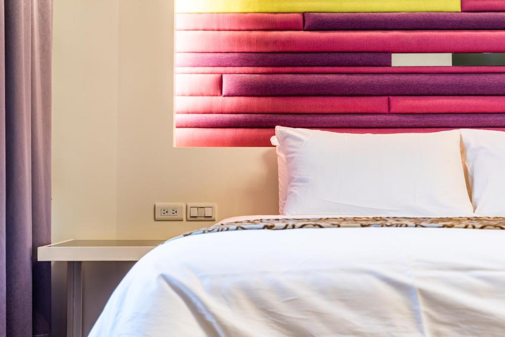 sypialnia z łóżkiem i kolorowym zagłówkiem w obiekcie Sakura VILLA B&B w mieście Yuanshan