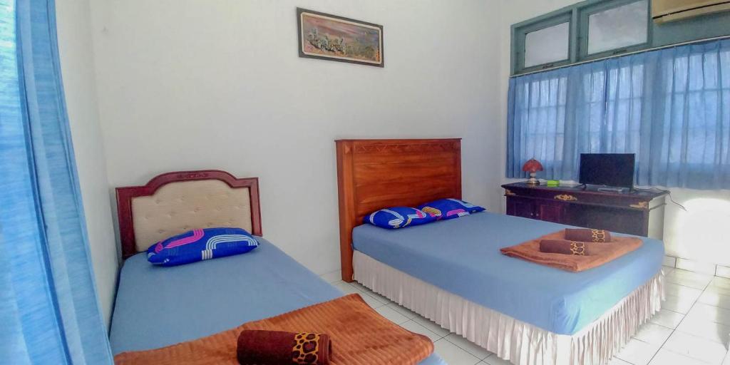una camera con 2 letti, una scrivania e una finestra di Hotel Rajawali Mitra RedDoorz a Cirebon
