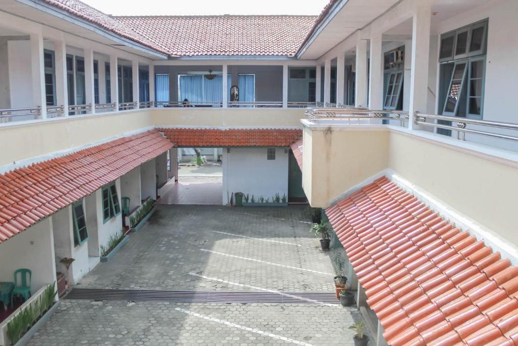 un cortile vuoto di un edificio con tetti rossi di Hotel Rajawali Mitra RedDoorz a Cirebon