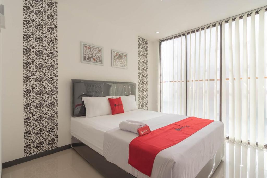 een slaapkamer met een groot wit bed met rode kussens bij KoolKost @ Regol Park (Minimum Stay 3 Nights) in Bandung
