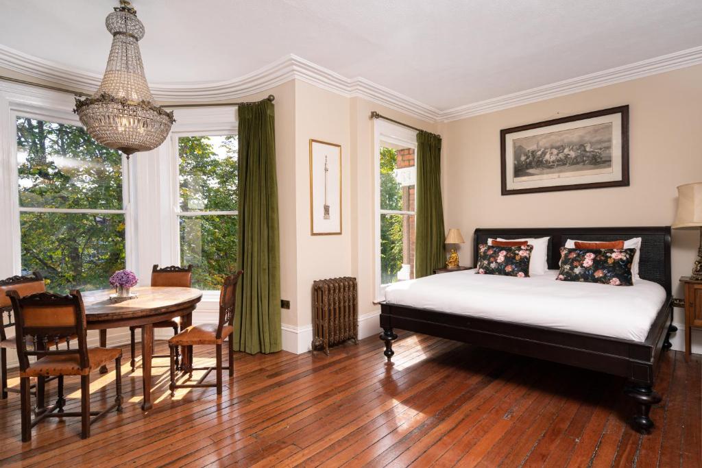 a bedroom with a bed and a table and a dining room at The Harrison Chambers of Distinction in Belfast